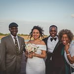 man in black suit jacket beside woman in white dress holding bouquet of flowers
